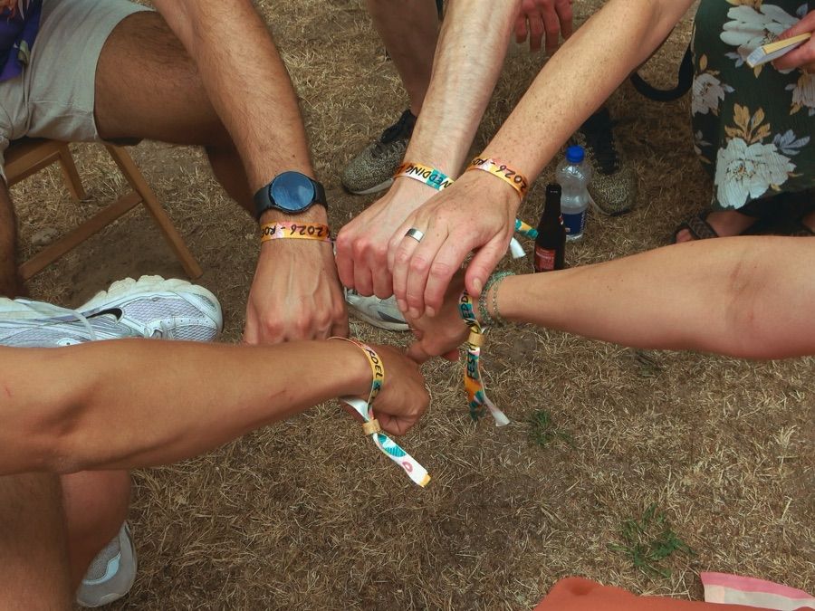 Handen met festivalbandjes op elkaar
